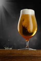 Glass of light beer on dark background. Frozen glass cold mug of beer.