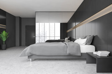 Black and grey bedroom with bed and linens, wardrobe and window