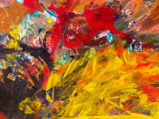 Abstract texture with yellow, red, black tempera paints on the palette.
