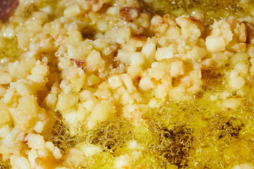 Chopped potatoes frying in extra virgin olive oil in the pan to make spanish omelet.