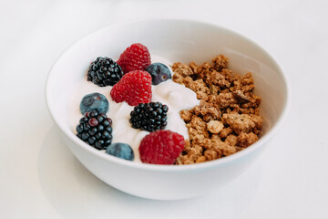 breakfast dish granola yogurt raspberries blueberries top