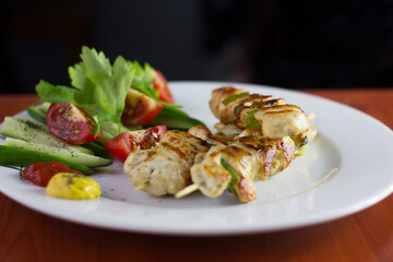Chicken shish kebab, grilled chicken with greens and tomato