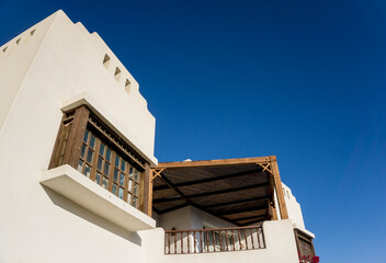 The view of top floor of house in the garden with balcony and roof