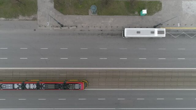 Aerial top-down shot of an empty main street in the city center with just one tram on the move