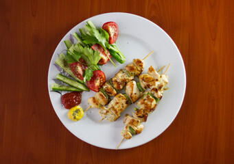 Chicken shish kebab, grilled chicken with greens and tomato