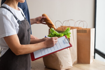 Food delivery. A man and a woman collect orders. It is noted in the checklist.