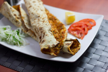 Traditional Turkish pizza (lahmacun) in a white plate