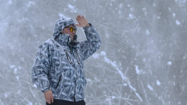 Man stands alone against white snowstorm and snow storm, a snowfall.