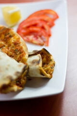 Traditional Turkish pizza (lahmacun) in a white plate