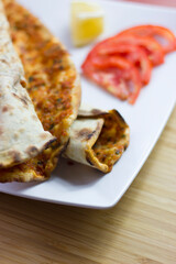 Traditional Turkish pizza (lahmacun) in a white plate