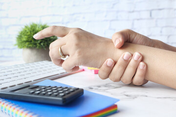  women suffering pain in hand while working on office 