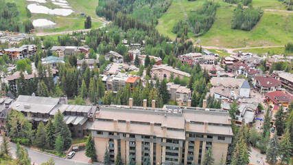 Fototapeta premium Vail city center and surrounding mountains, Colorado. Aerial view from drone in summer season