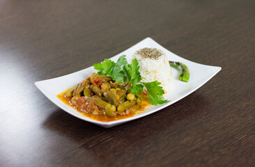 Okra with rice and parsley in a white plate