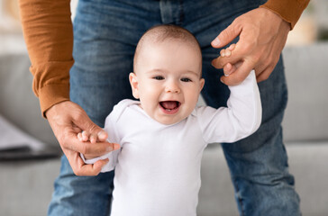 Daddy Helping His Baby Walk, Make First Steps At Home