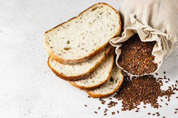 Flax seeds in a sack, slices of bread. Space for text, top view, flat lay.