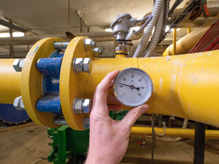 Worker control tepmerature in pipe delivery system.  Large yellow sludge pipe