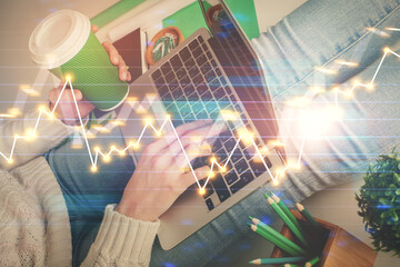 Double exposure of woman hands typing on computer and forex chart hologram drawing. Stock market...
