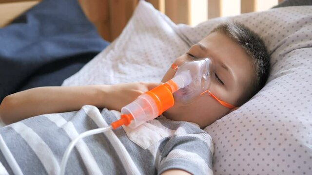 Little boy is treated with a nebulizer, cough. Small boy does therapeutic inhalation using a nebulizer