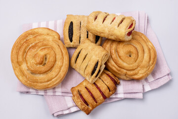 Variety of Tasty Homemade Buns Buns with Jam and Rolls Pink Napkin Blue Background Horizontal