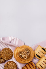 Variety of Tasty Homemade Buns and Cookies Buns with Jam and Rolls Pink Napkin Blue Background Vertical Copy Space