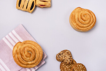 Variety of Tasty Homemade Buns and Cookies Buns with Jam and Rolls Pink Napkin Blue Background Horizontal Frame