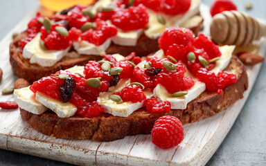 Raspberry and brie sourdough bread toast with pumpkin seeds and drizzled with honey