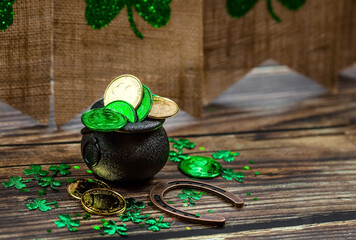 Background for St. Patrick's Day, March 17, with a lucky horseshoe, clover and a pot of gold on a...