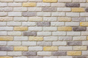 Wall with decorative plaster facing bricks following the example of antique tiles in white, yellow and gray. Original background, pattern for graphic works and design