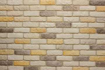 Wall with decorative plaster facing bricks following the example of antique tiles in white, yellow and gray. Original background, pattern for graphic works and design