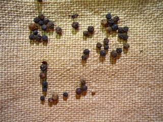 Black pepper isolated on wooden board and burlap