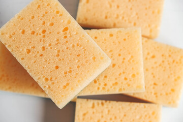 Yellow porous sponges on a white background. Top view. Copy, empty space for text