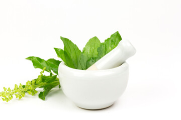 Tulsi or Holy basil leaf in mortar with pestle isolated on white background. Tulsi is used in...