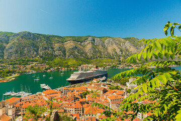 Colorful landscape with boats in marina bay, sea, mountains, blue sky. Top view of Kotor bay, Montenegro