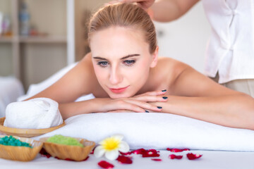 Obraz na płótnie Canvas Beautiful young attractive Caucasian woman having body massage by Thai Masseur in spa salon. Beauty treatment and body care lifestyle concept 