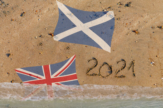 2021 in Sand geschrieben , Schottische Flagge, Britische Flagge wird von wasser &uuml;bersp&uuml;lt