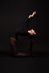 Obraz premium A female gymnast on black background