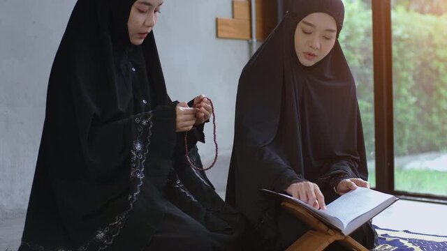 Portrait of an Asian muslim women in a daily prayer at home reciting Surah al-Fatiha passage of the Qur'an in a single act of Sujud called a Sajdah or prostration