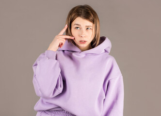 Portrait of confused beautiful girl expressing distrust and suspicion,studio shot on gray background