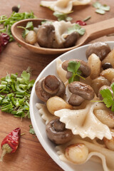 Pasta farfalle with grilled mushrooms and onions with spice, fresh parsley and onions