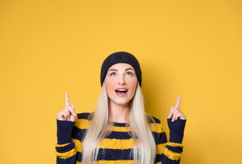 Young woman looking up and pointing to shows your space for product, isolated on white background