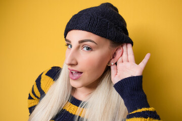 Close up woman holding palm near his ear trying to listen something interesting, model wearing...