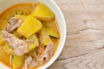 spicy boiled pumpkin with slice pork in curry on bowl