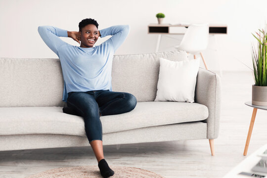 Black woman having rest at home on the couch
