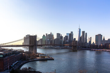 Fototapeta na wymiar New York City skyline with skyscrapers at sunset. Brooklyn bridge as a connection between Manhattan and Brooklyn