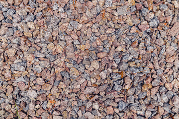 Background of natural grey granite crushed stone, macadam. Macro photo of texture of broken stone or rubble with place for text. Crushed rock. Construction Materials. Textures.