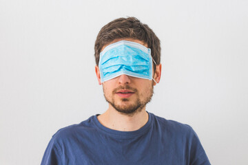 Conspiracy theory concept: Young man with face mask over the eyes