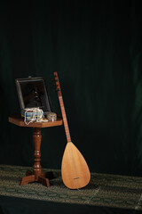 Still life in turkish Muslim ottoman oriental style. Turkish national musical instrument baglama saz, jewelry box and mirror on the table