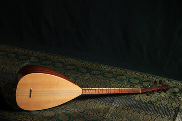 traditional Turkish national musical instrument baglama saz on a dark green background. a magnificent century. The concept of Islam