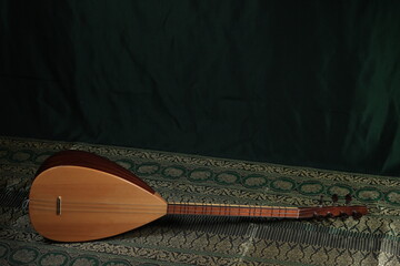traditional Turkish national musical instrument baglama saz on a dark green background. a magnificent century. The concept of Islam