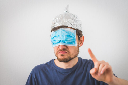 Conspiracy Theory Concept: Young Angry Man Is Wearing Aluminum Hat Is Gesturing Angry.